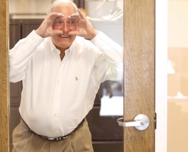 Man staring through a glass office door playfully